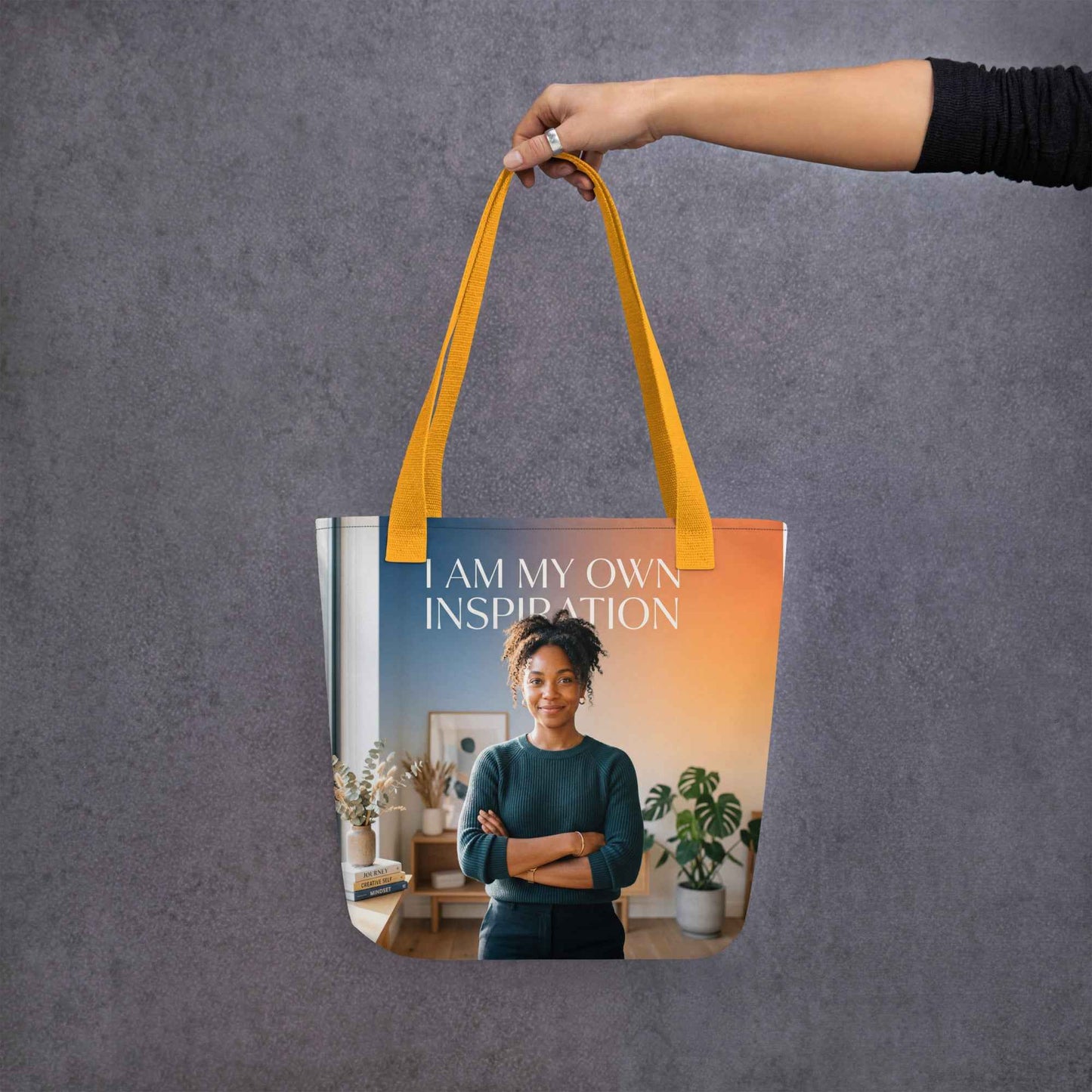 Yellow tote bag with handles and front panel text 'I AM MY OWN INSPIRATION'