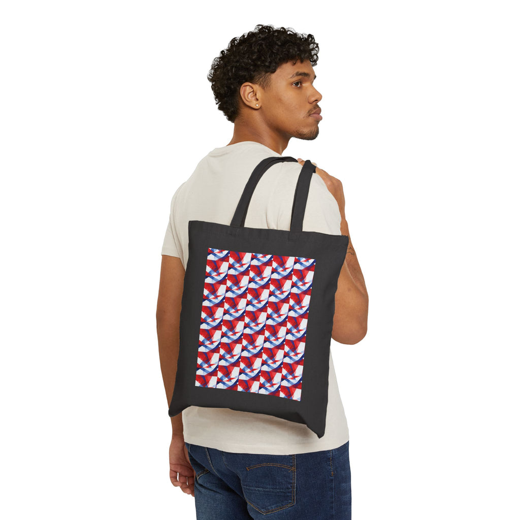Black canvas tote worn by man; red-white-blue geometric flag print panel on front.