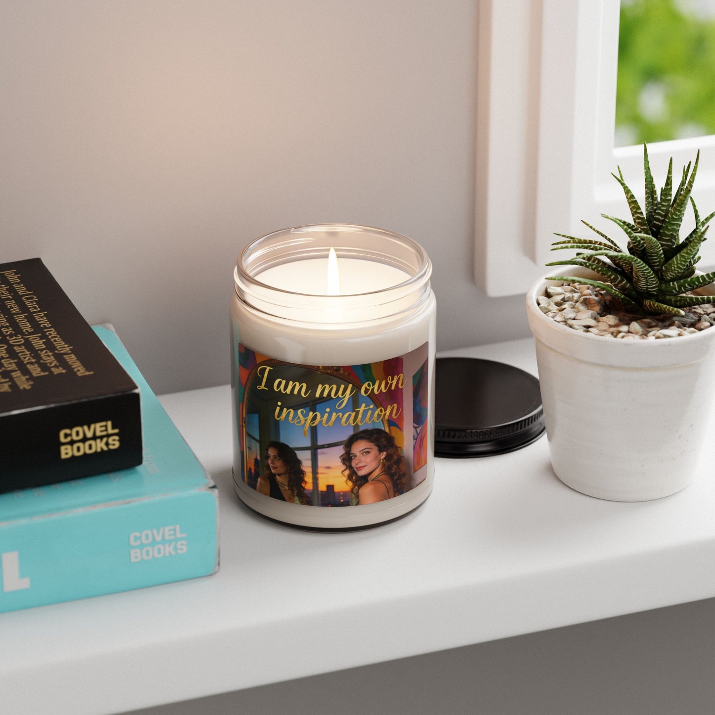 Lit soy candle in clear glass jar with “I am my own inspiration” label, white wax flame