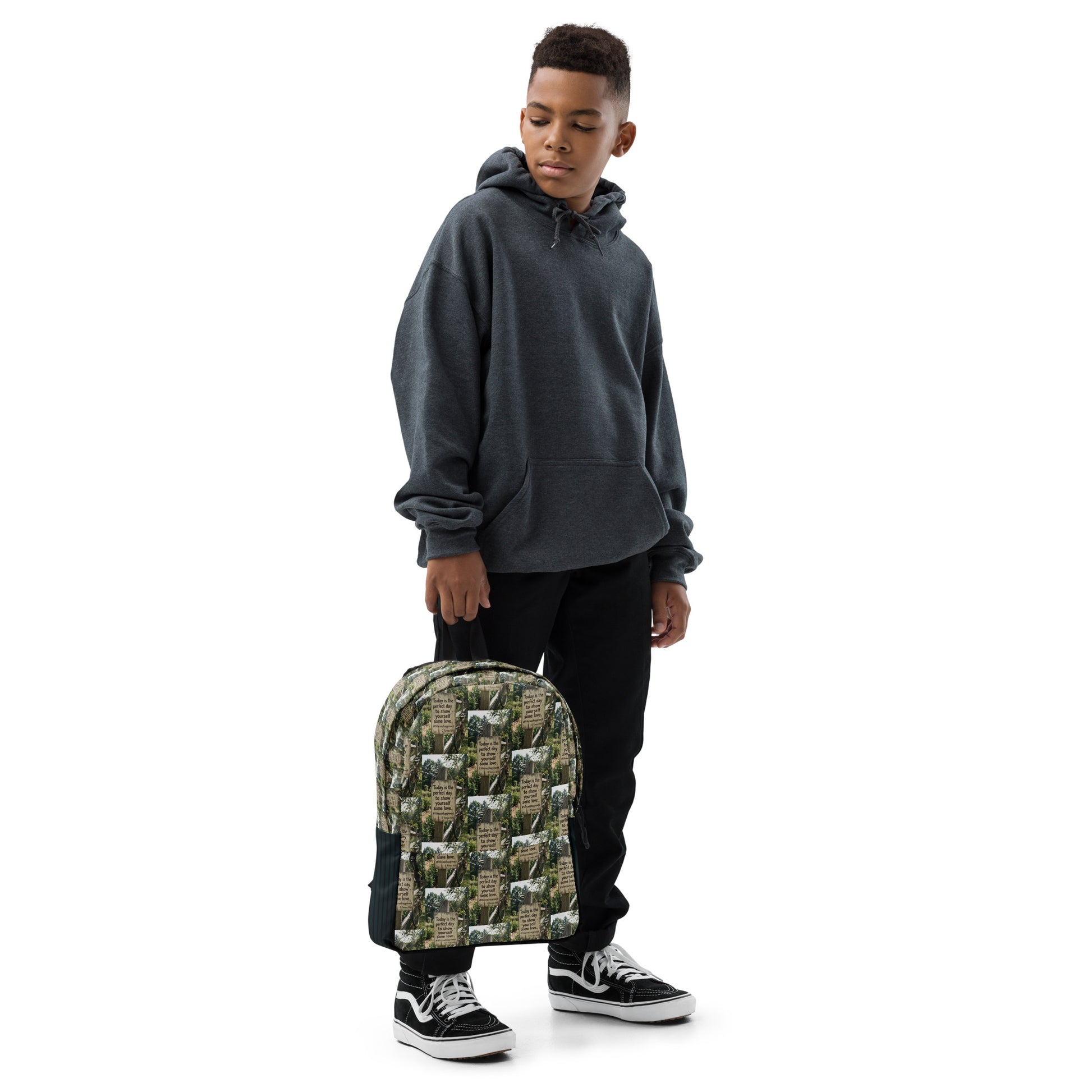 Green quote-pattern backpack with black side panels, front pocket, and adjustable straps.