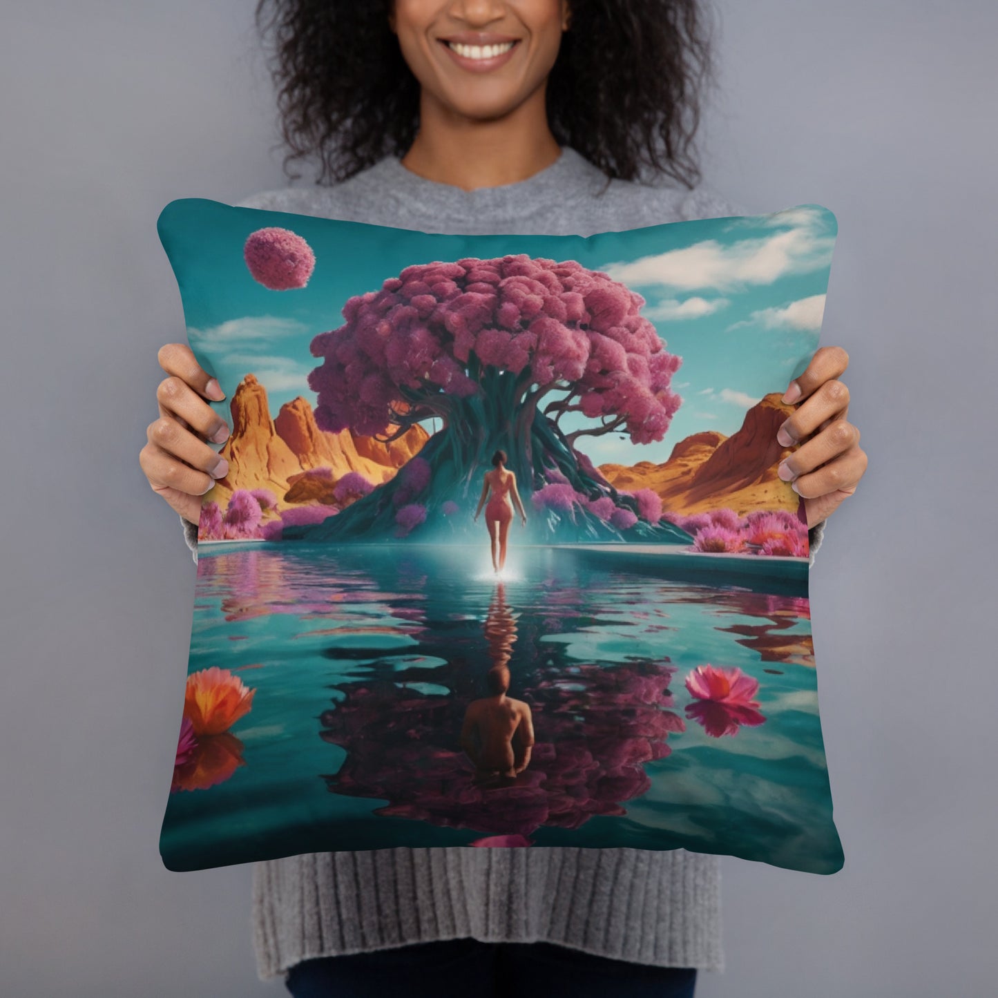 Square teal accent pillow held up, featuring a surreal tree and mirrored water scene