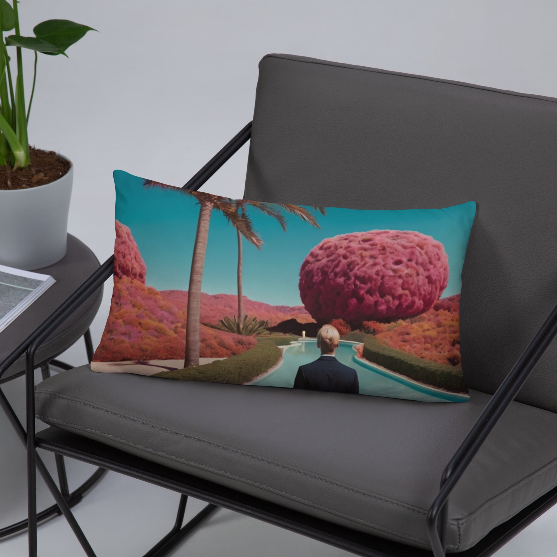 Rectangular accent pillow with teal landscape print, pink tree, palms, and person facing river