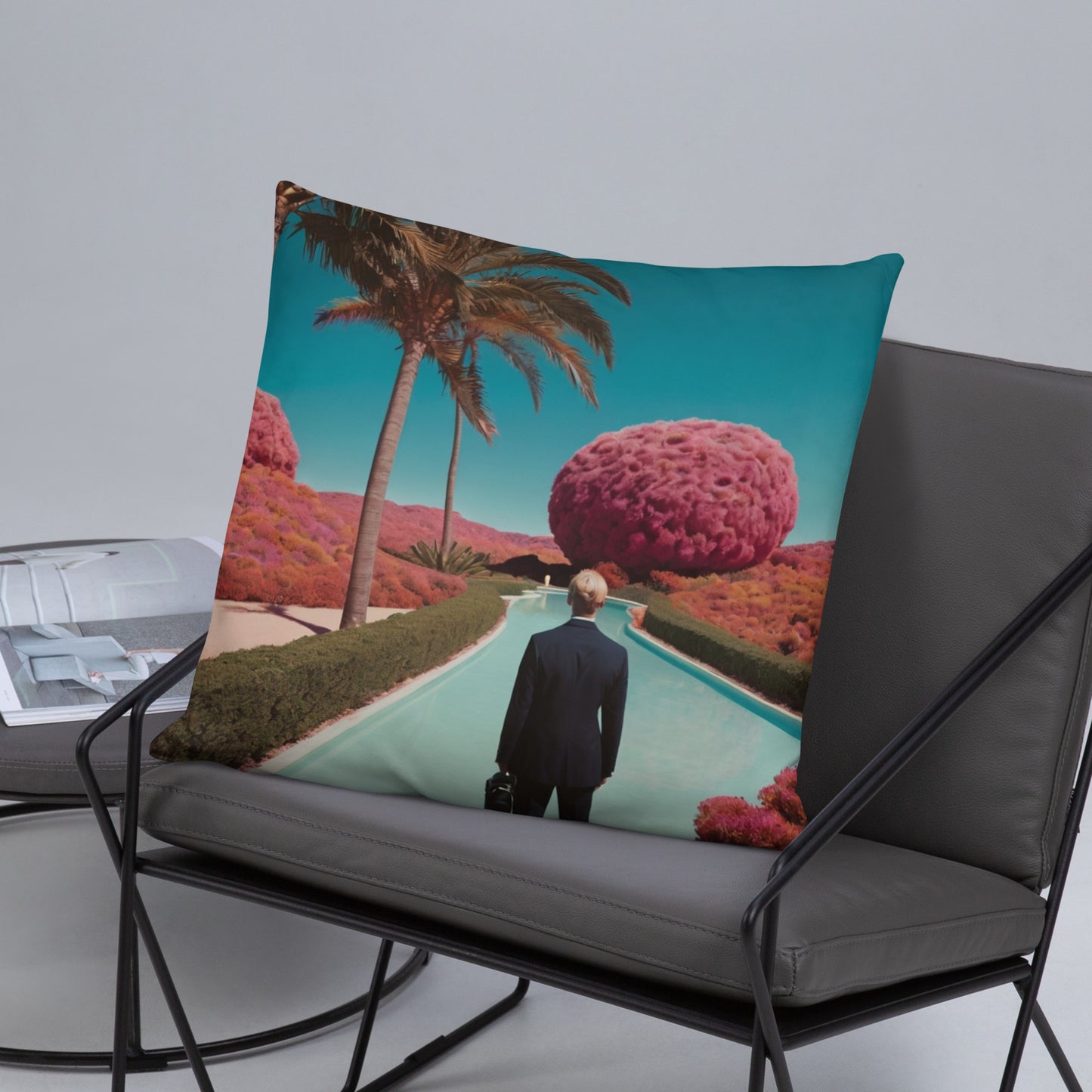 Teal accent pillow featuring pool landscape with palm tree and a man standing in center