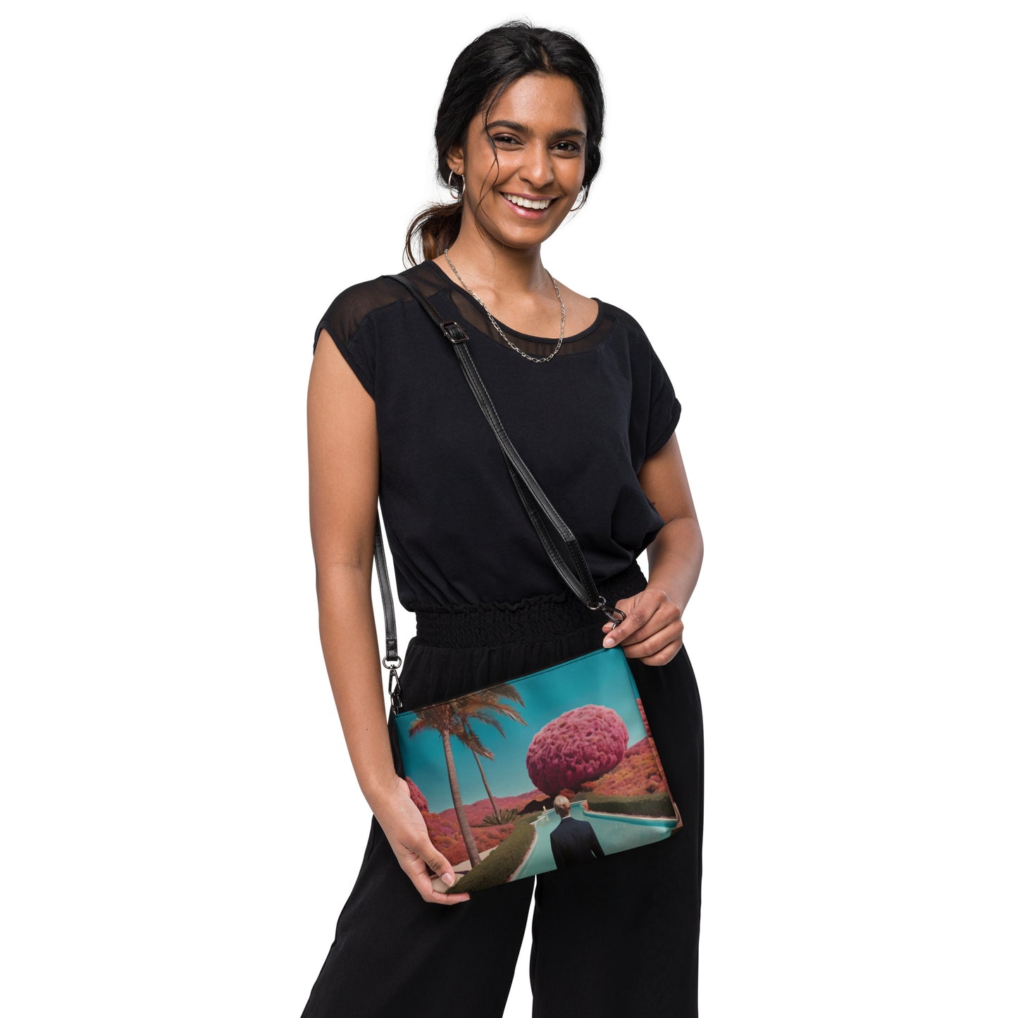 Teal crossbody bag with zipper and scenic print, worn with black outfit