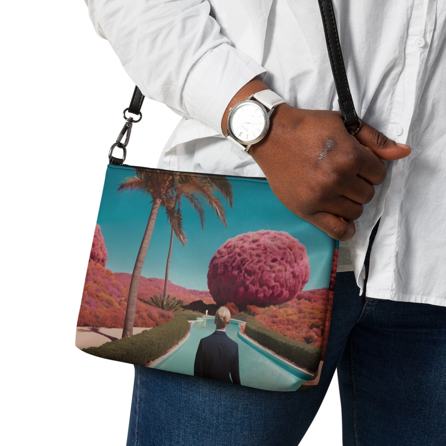 Teal crossbody bag with zipper and scenic print, held at side on a man