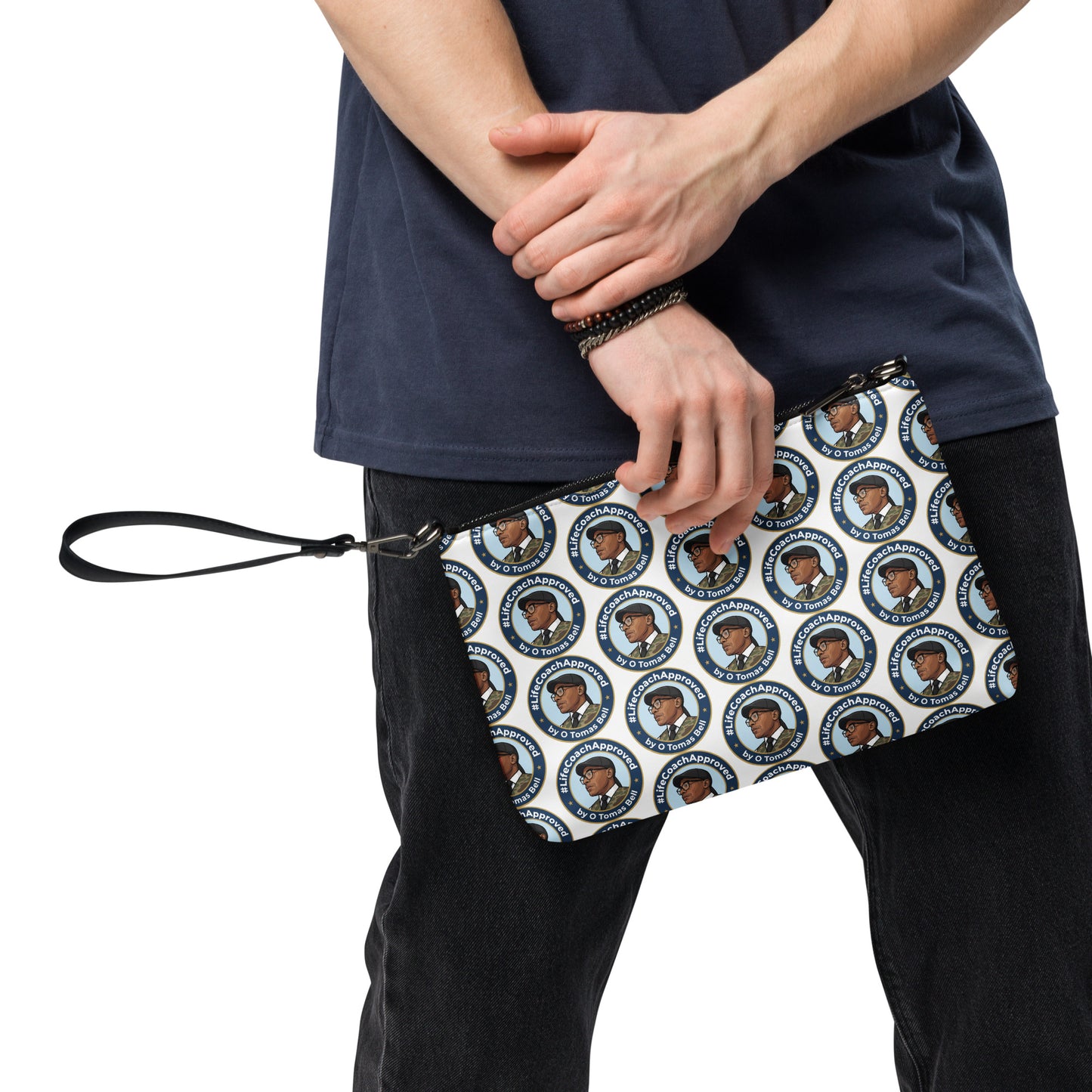 Printed crossbody bag held by hands, black strap with blue circular pattern front panel