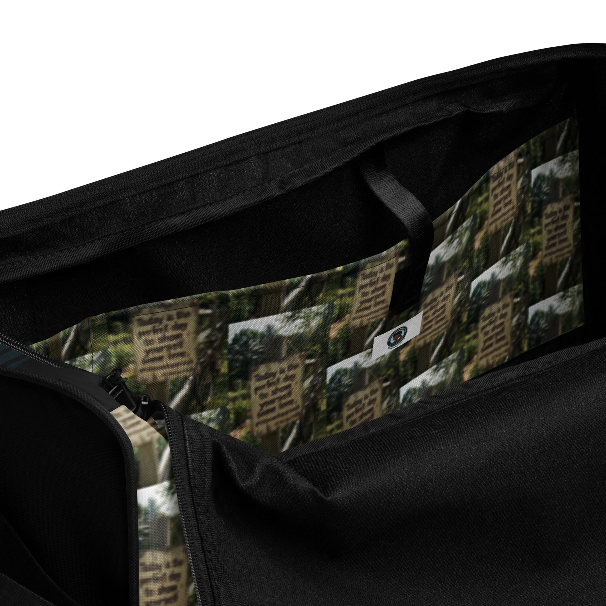 Duffel bag close-up: black zipper, green collage lining, and oval logo patch