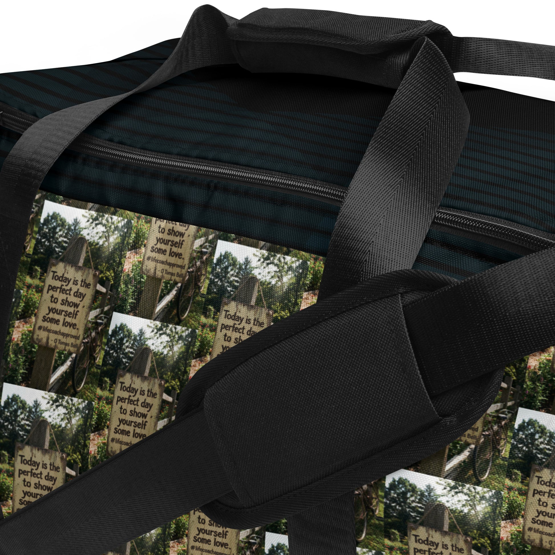 Black duffle bag with open zipper showing interior stripes and forest-and-quote graphic.