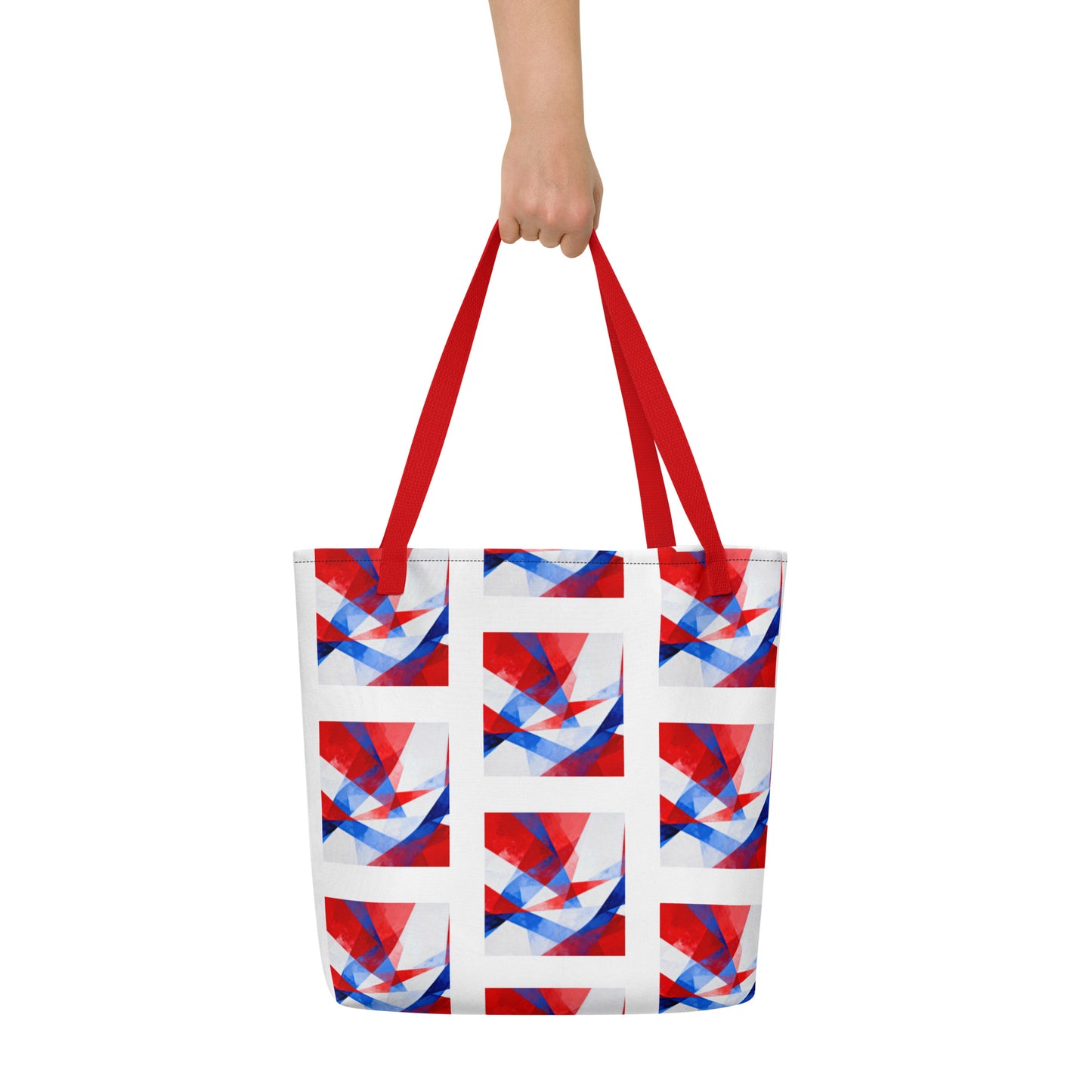 Beach tote bag held by red handles, featuring white, red, and blue geometric pattern