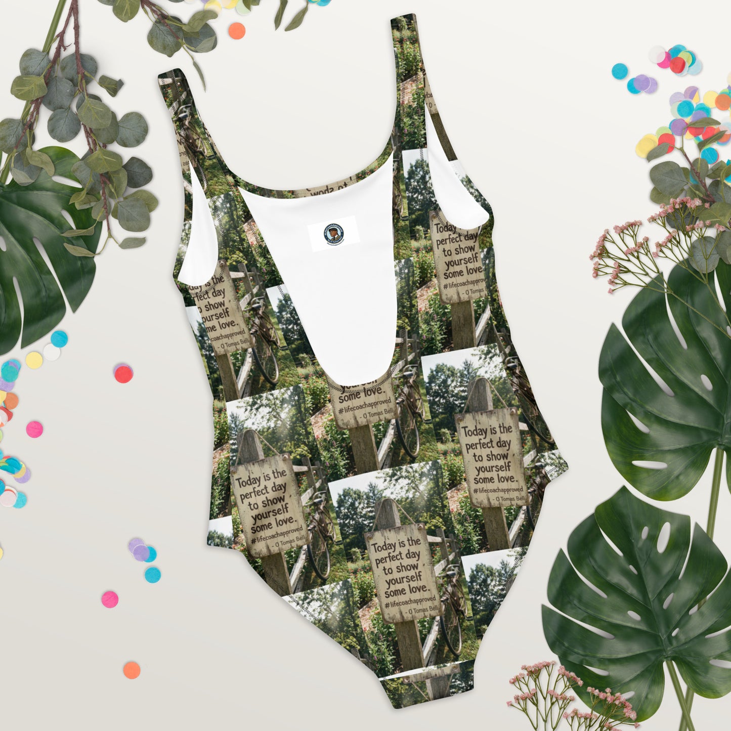 Self love one-piece swimsuit with green-and-white graphic sign print and wide U neckline.