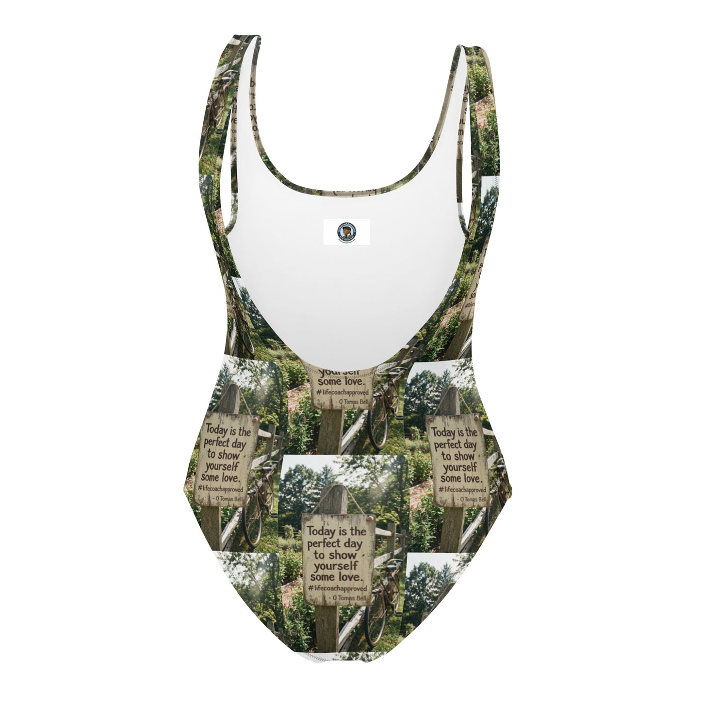 Self love one-piece swimsuit with green-and-white sign print and small logo patch at chest.