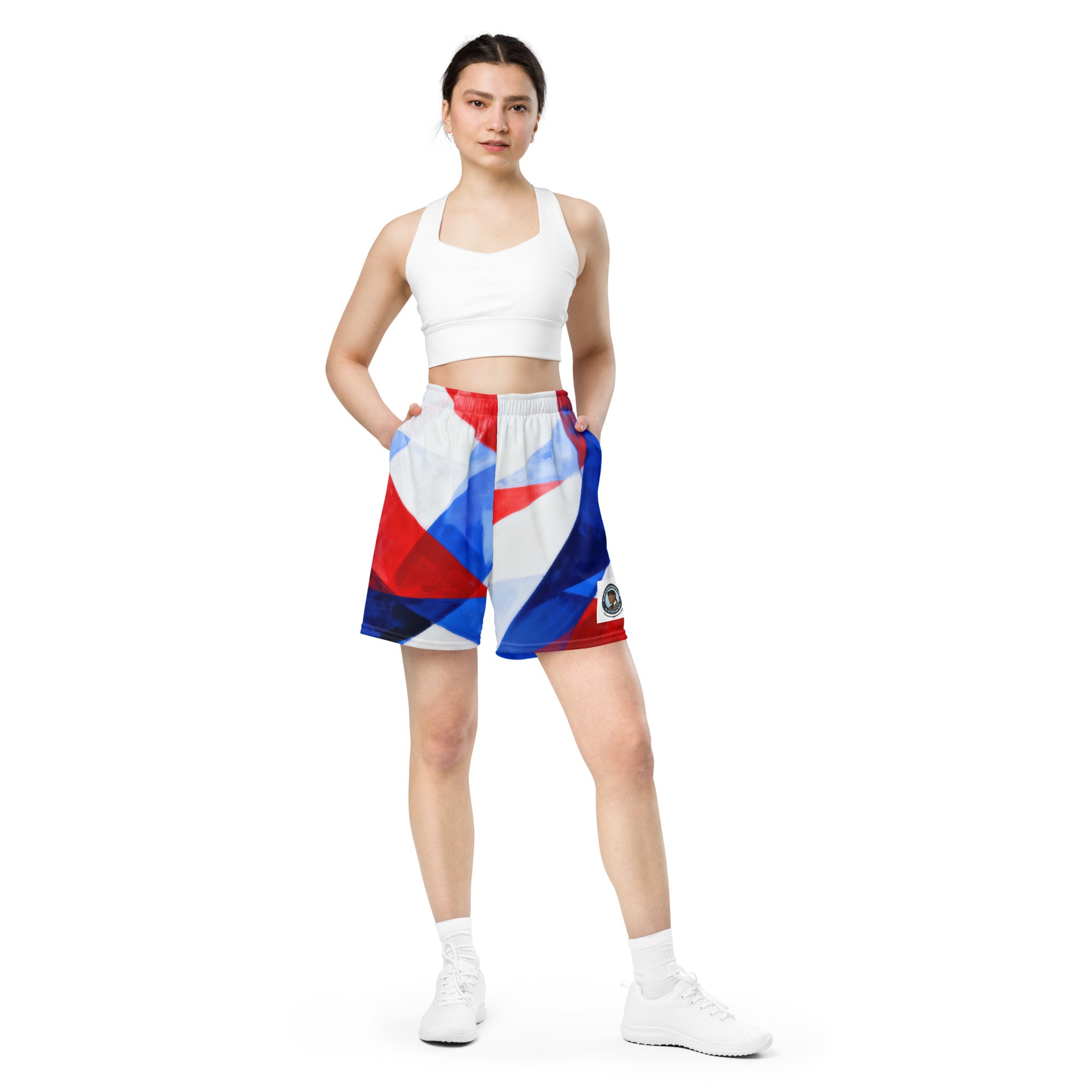 Mesh athletic shorts with white base and red, blue geometric print; elastic waistband