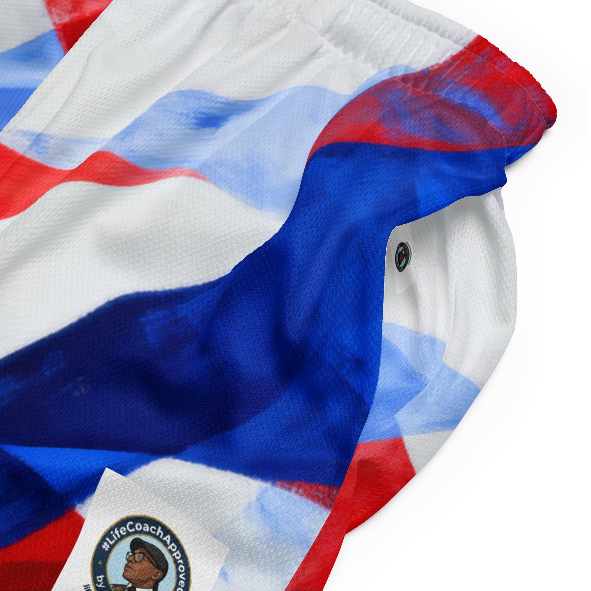 Unisex mesh shorts fabric close-up with red, white, and blue pattern and logo patch