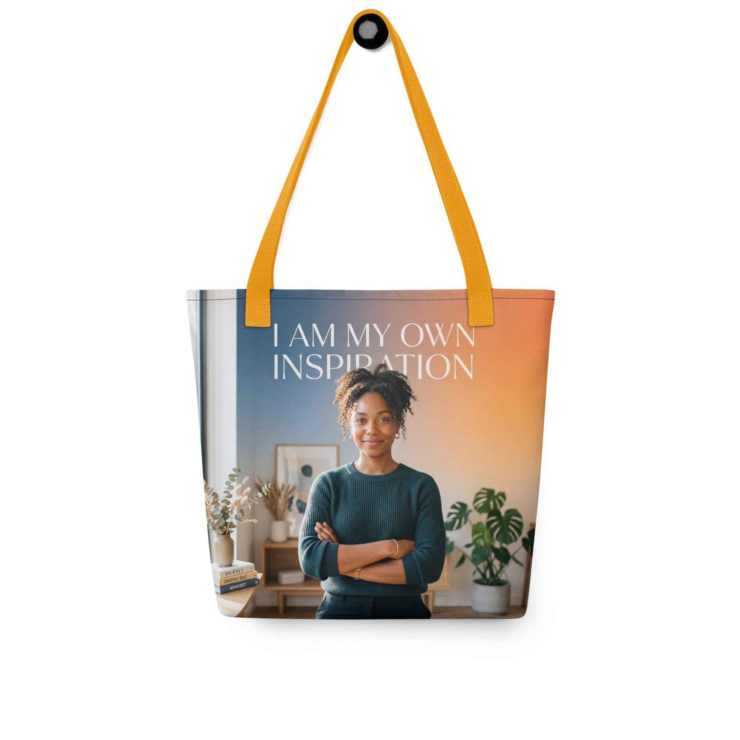Printed tote bag with yellow handles; “I AM MY OWN INSPIRATION” text over portrait image.