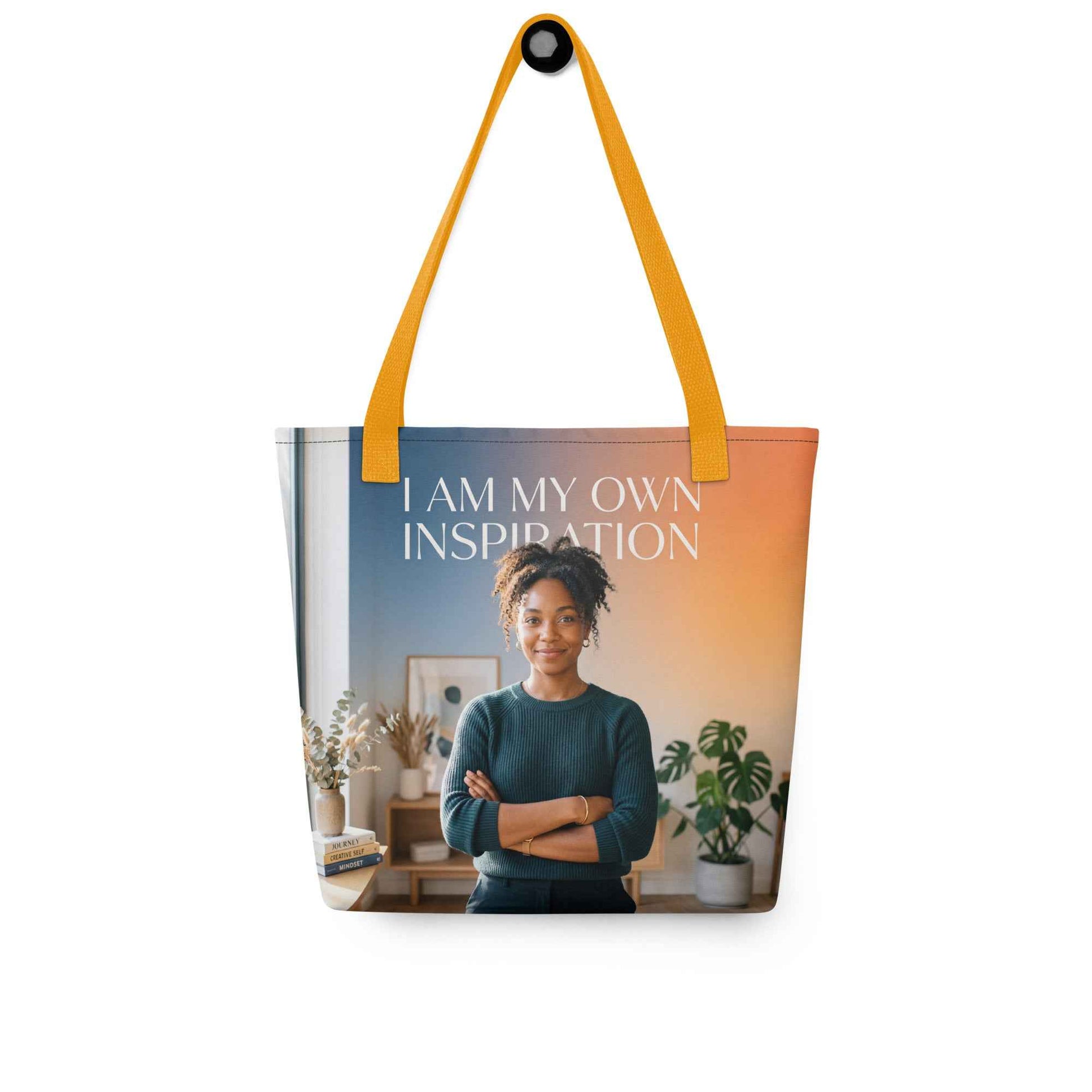 Printed tote bag with yellow handles; “I AM MY OWN INSPIRATION” text over portrait image.
