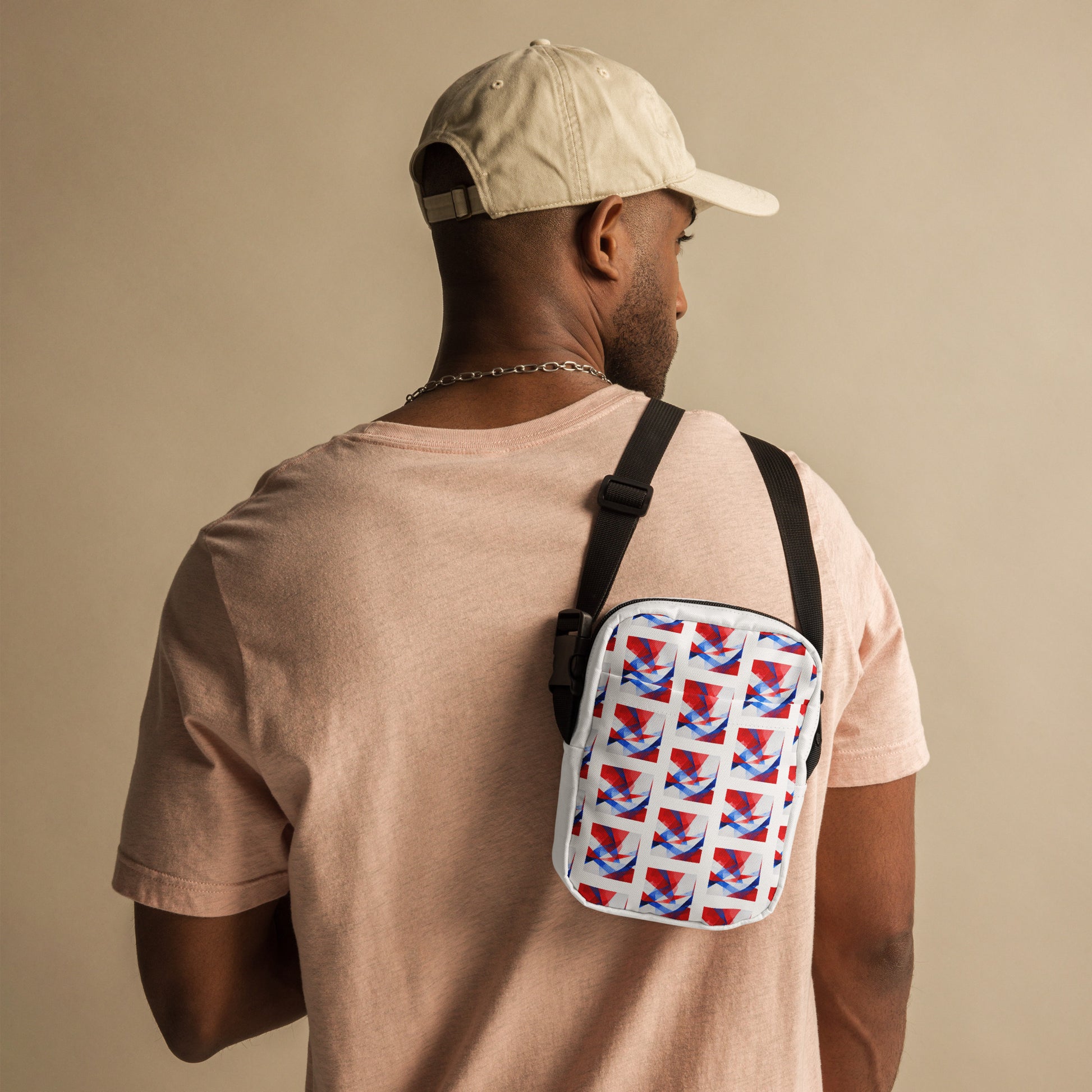 Utility crossbody bag with white UK flag pattern and black adjustable strap, worn on back.