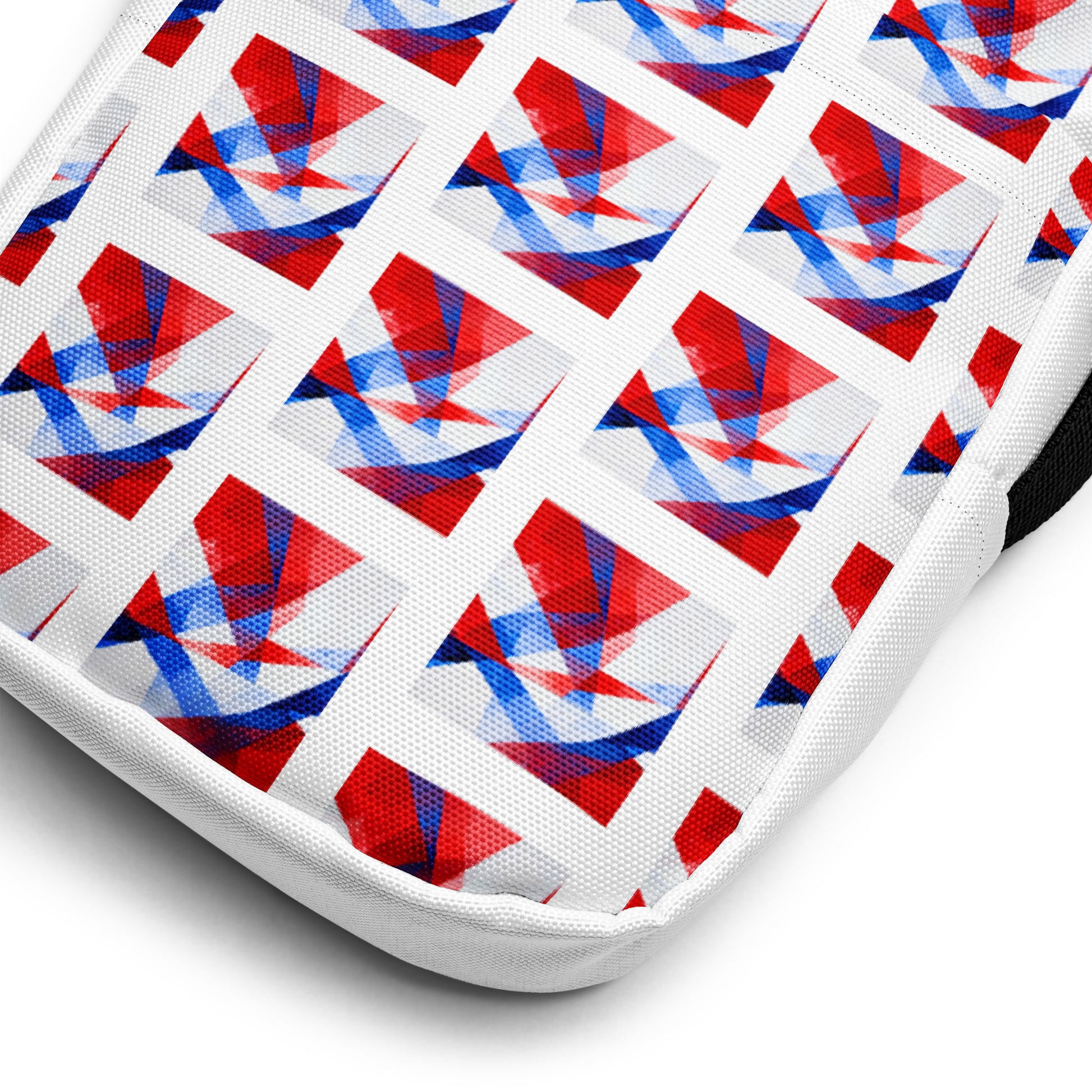 Close-up of white utility crossbody bag fabric with repeating UK flag pattern and black edge trim.
