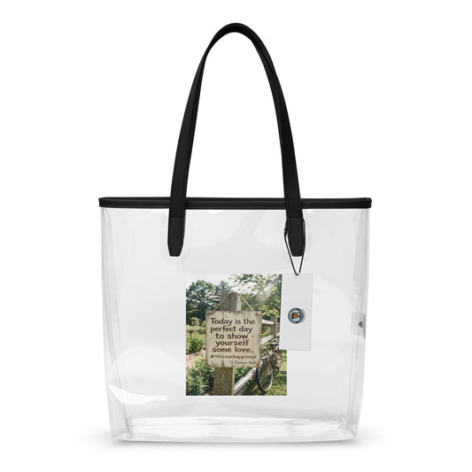 Clear tote bag with black handles and a printed inspirational panel on the front