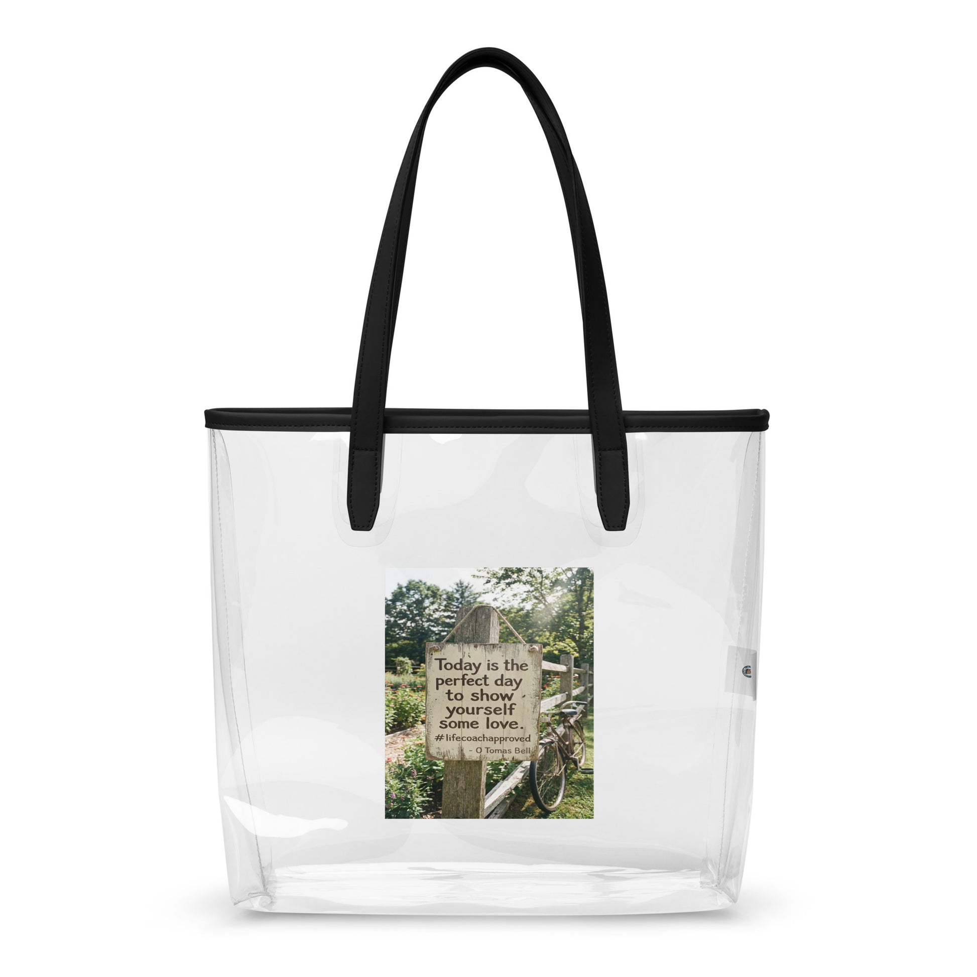Clear tote bag with black handles and a front printed inspirational photo panel