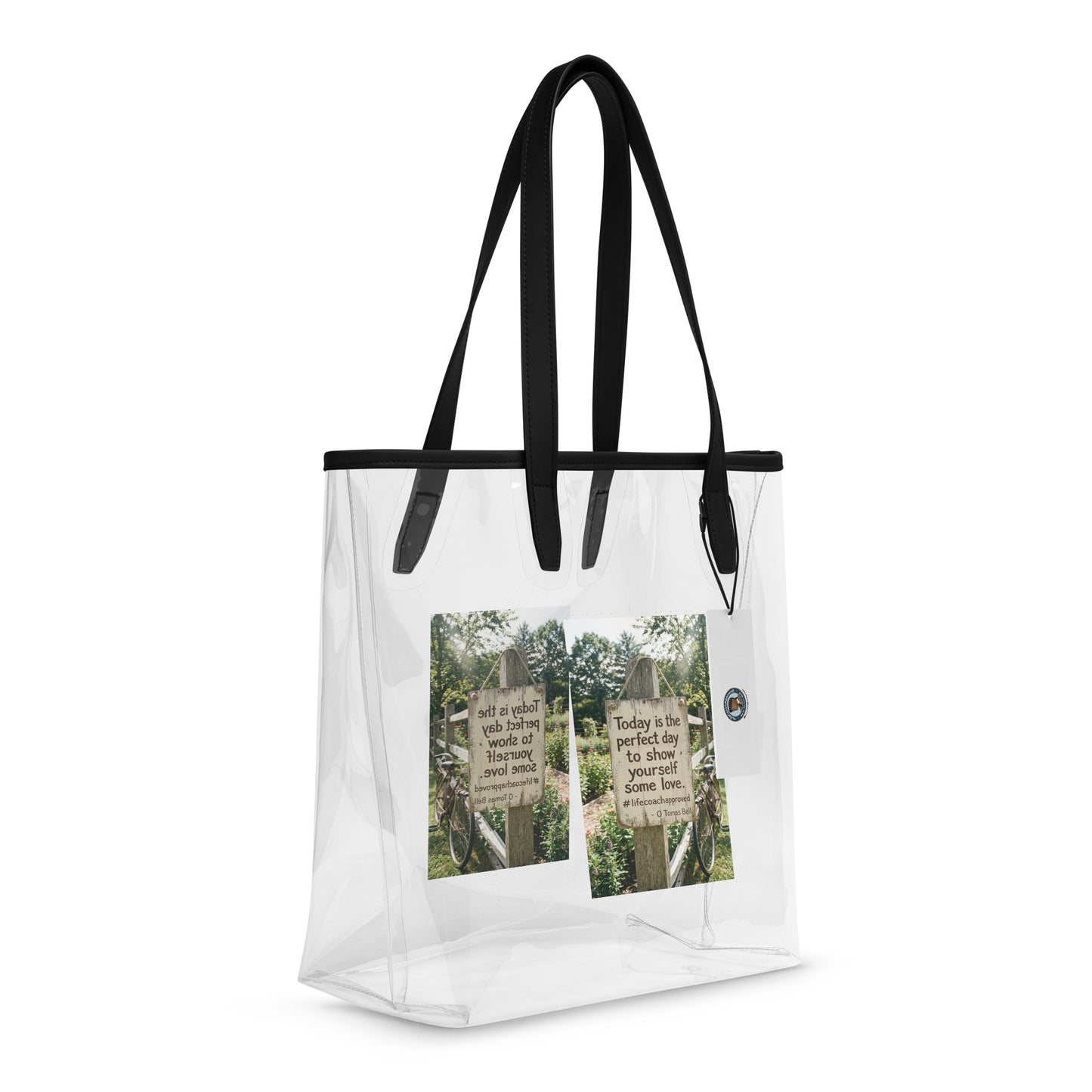 Clear tote bag with black handles and multiple printed inspirational panels inside