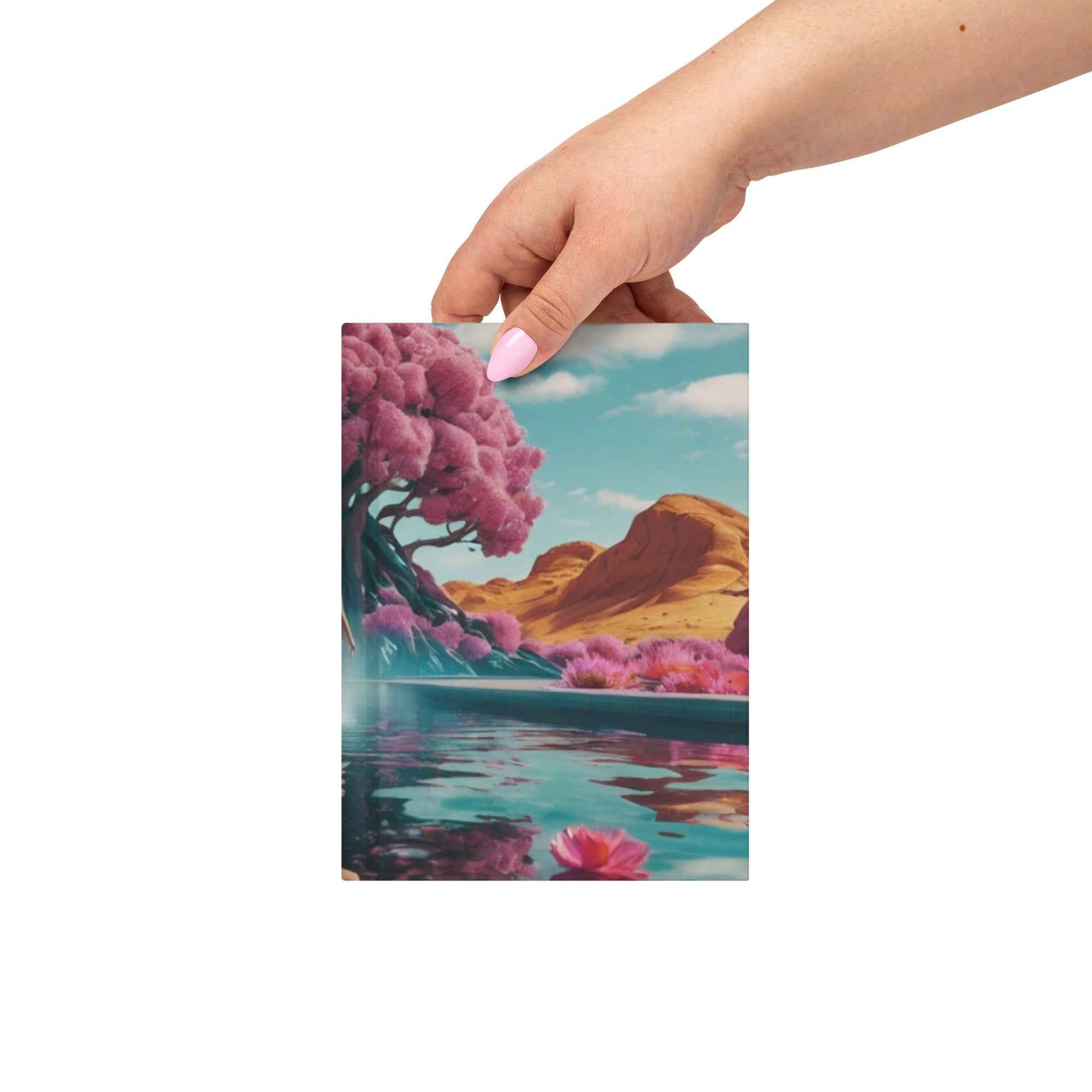 Matte hardcover journal held in hand with landscape cover art and magenta flowers