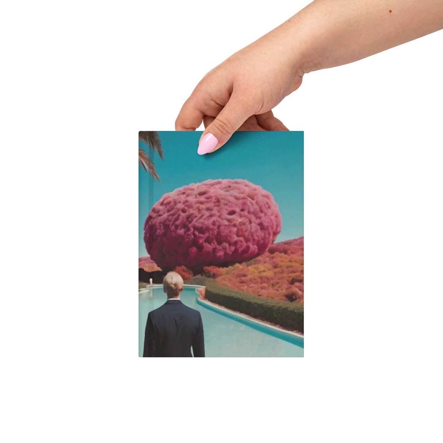 Hand holding matte hardcover journal with teal cover and pink tree-like dome