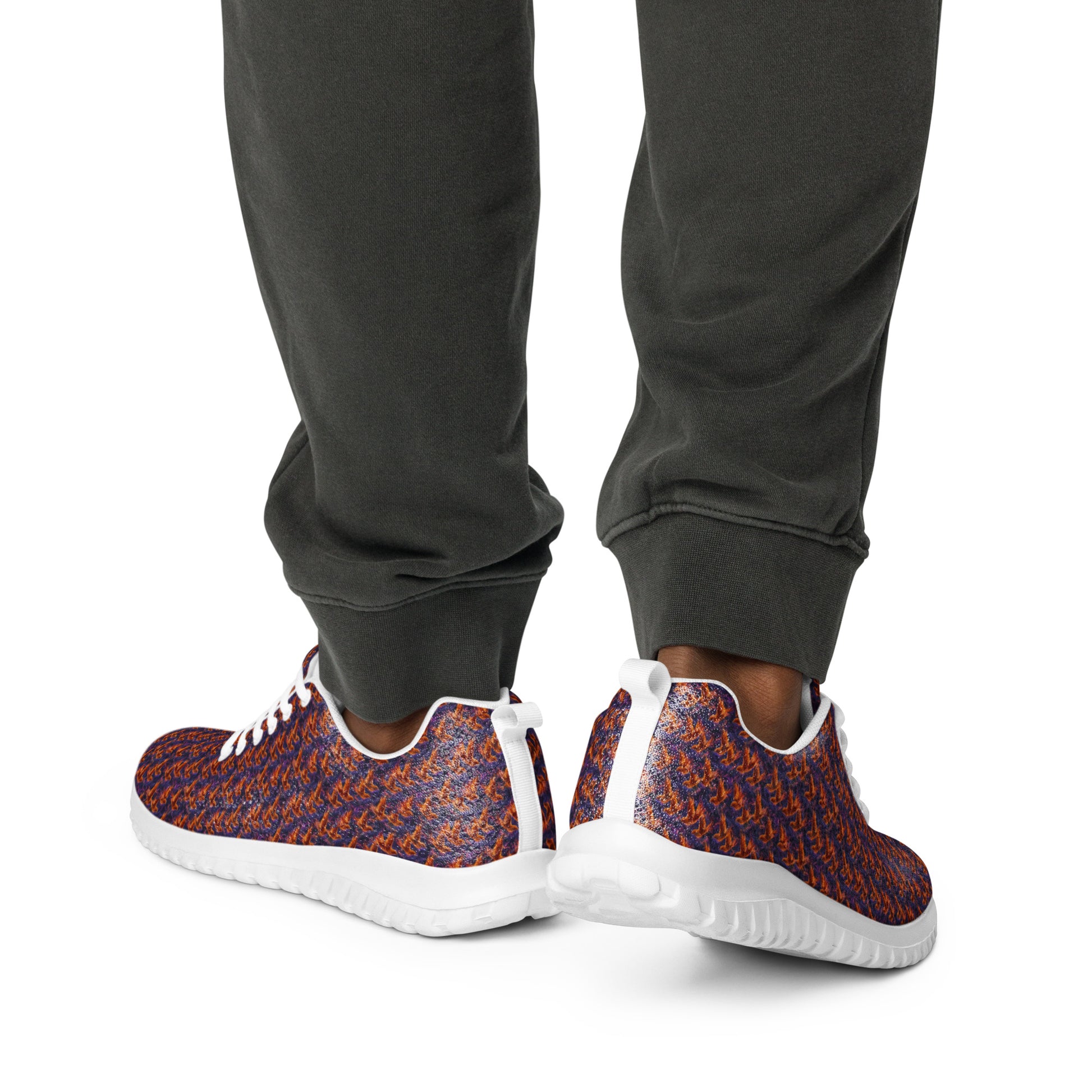 Athletic sneakers on legs showing white midsole tread and orange-blue knit upper
