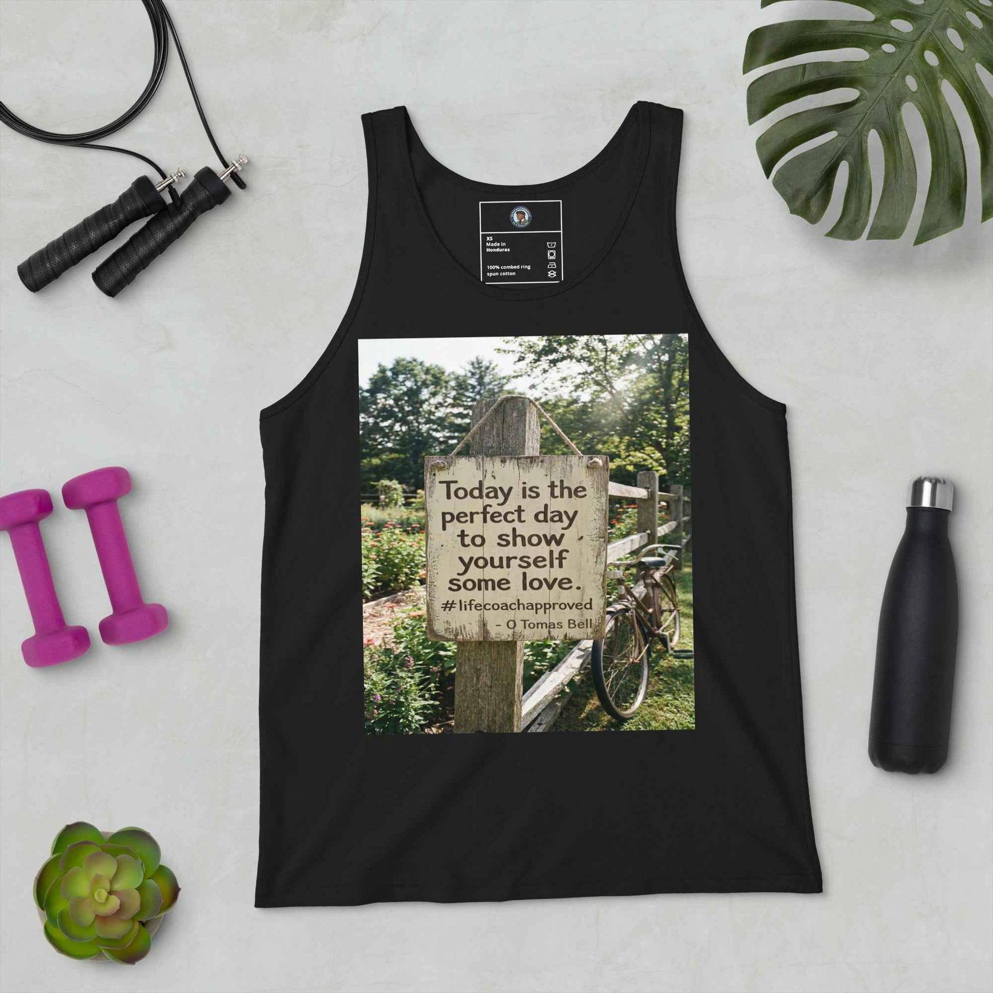 Black unisex tank top laid flat with scoop neck, size tag, and front graphic square.