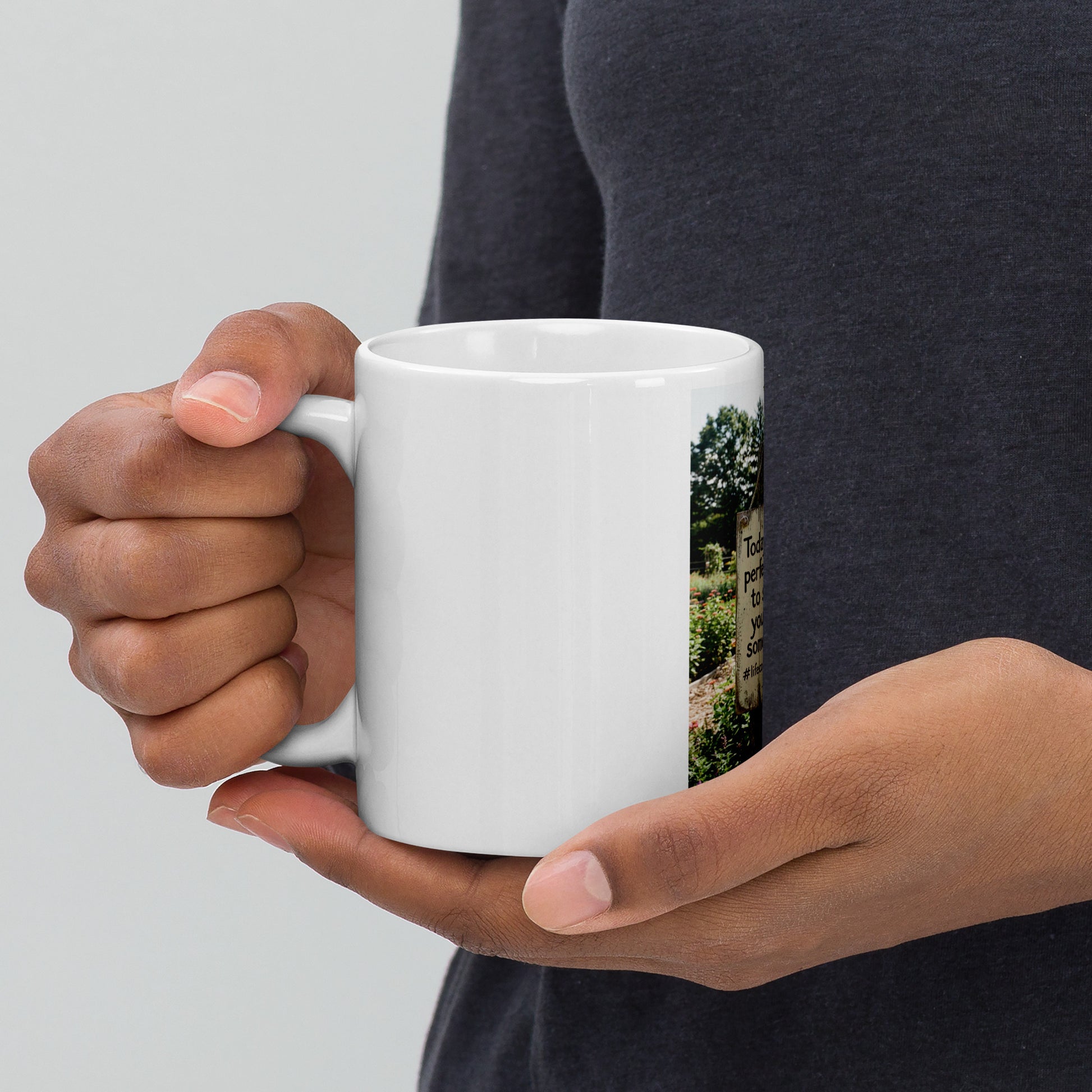White glossy mug held by one hand, front graphic with quote panel