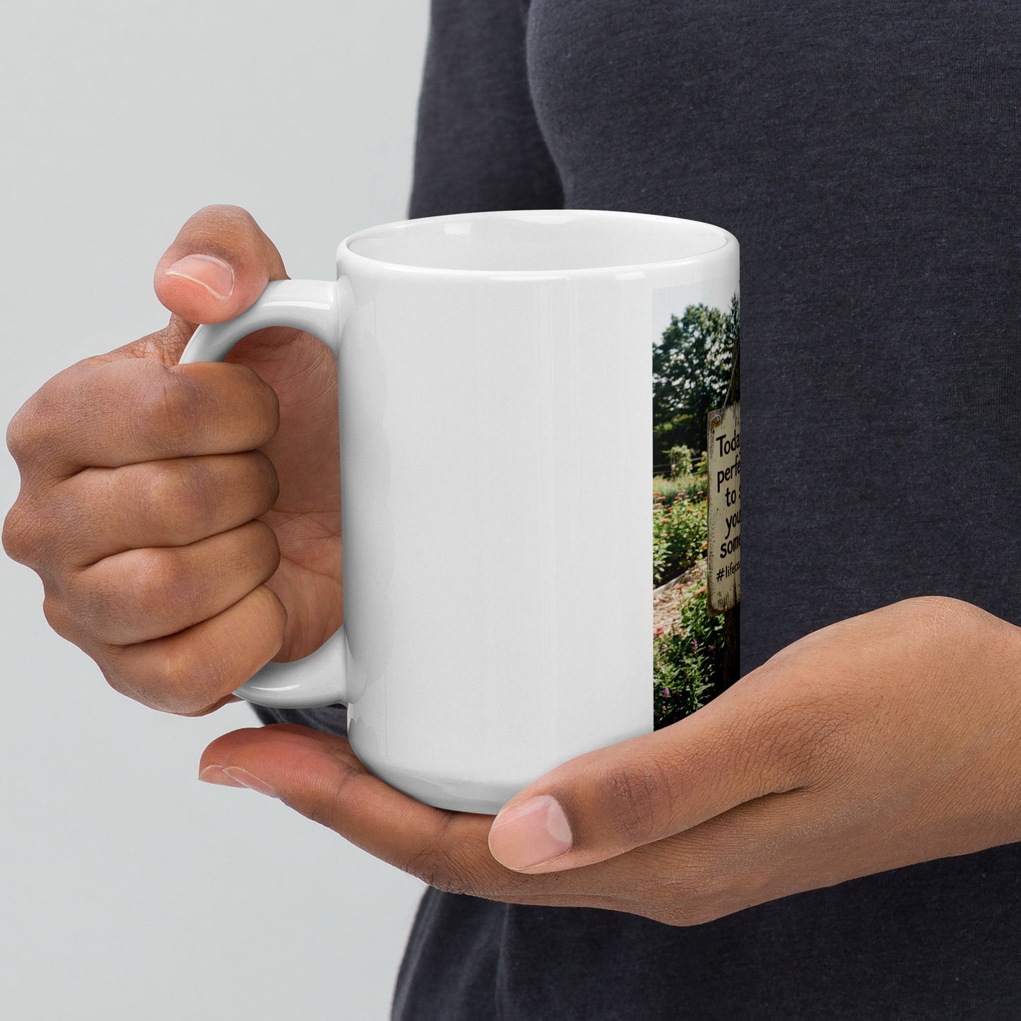 White glossy mug held in hands, front quote graphic panel visible