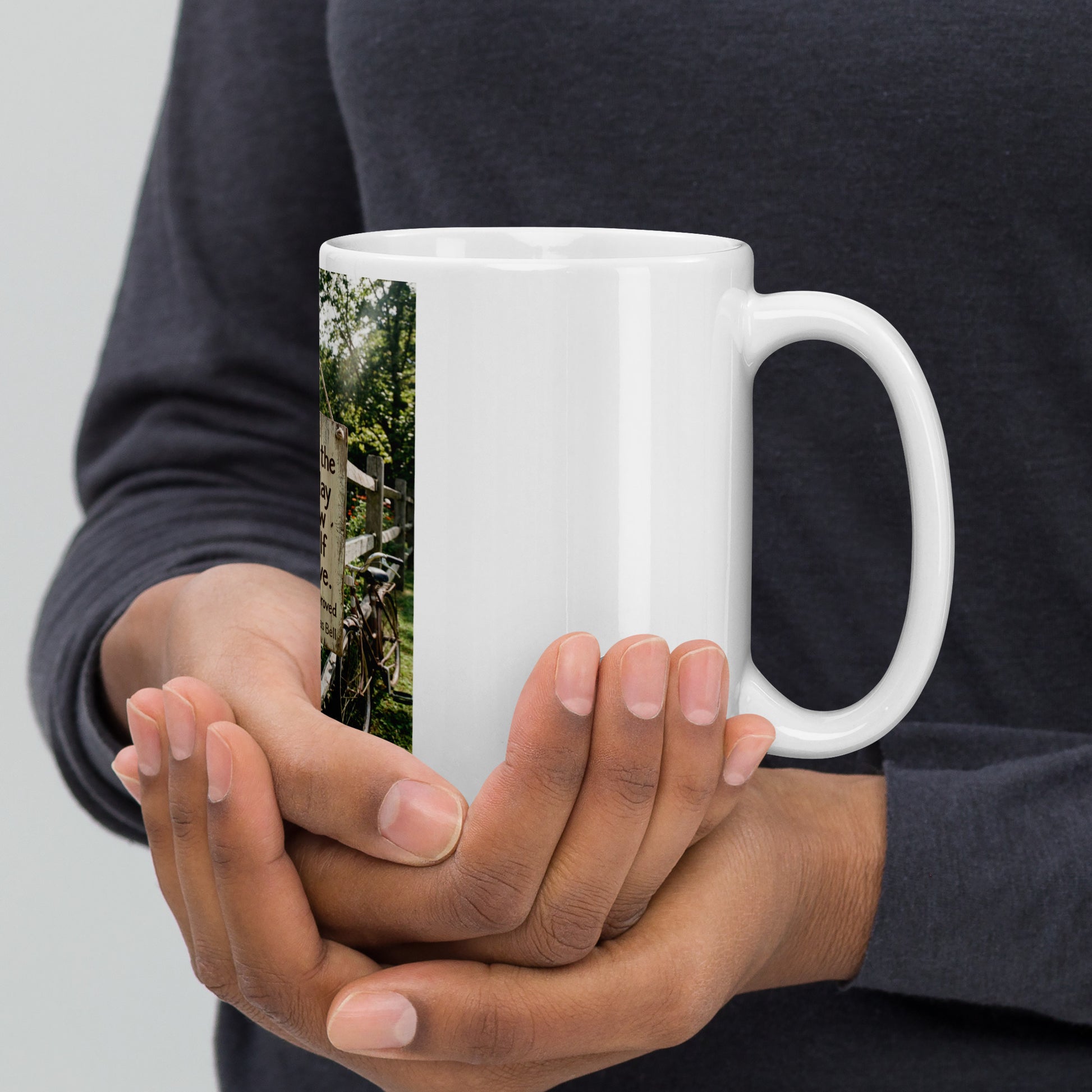 White glossy mug held with both hands, quote graphic panel on side