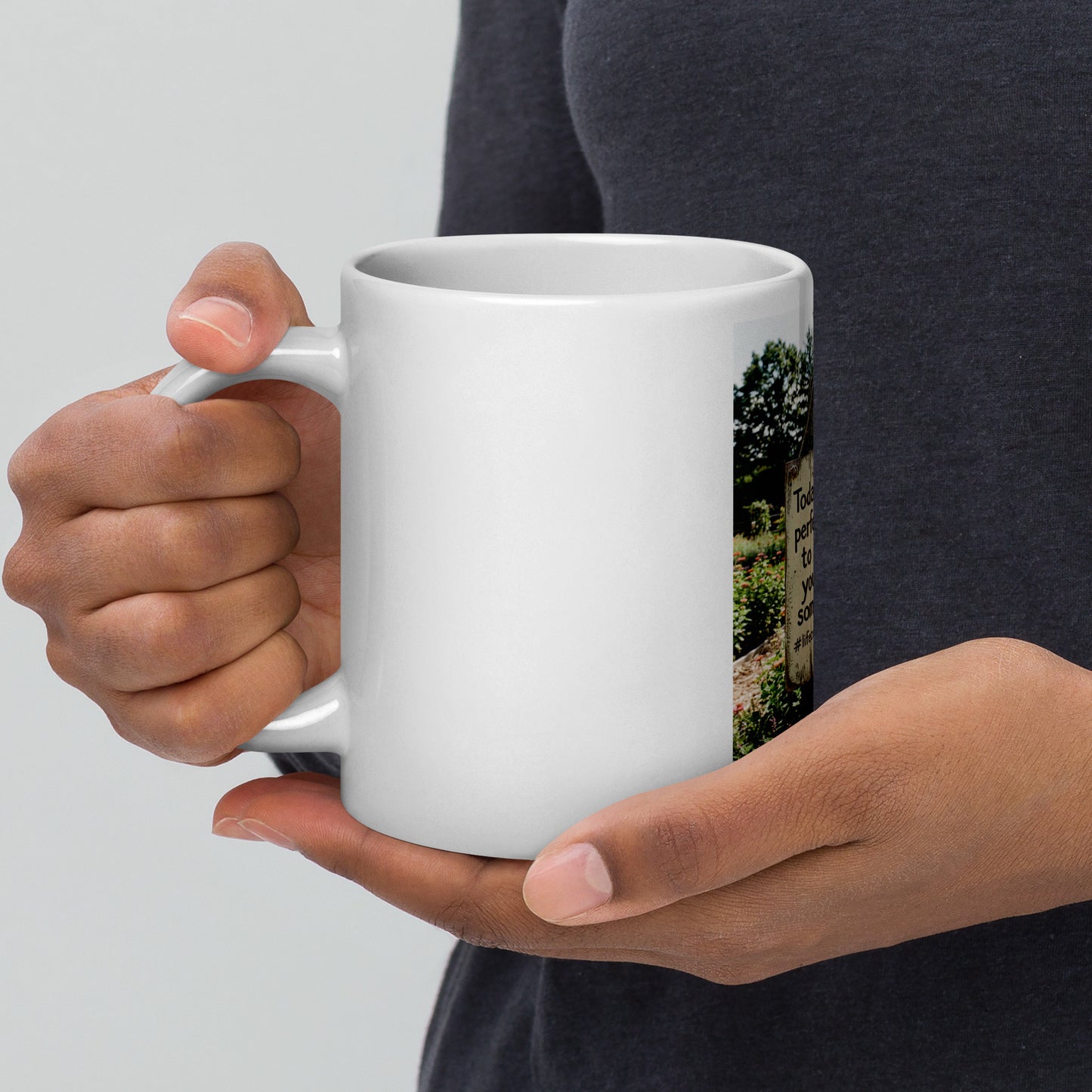 White glossy mug held in hand, side photo print visible, curved handle and open top